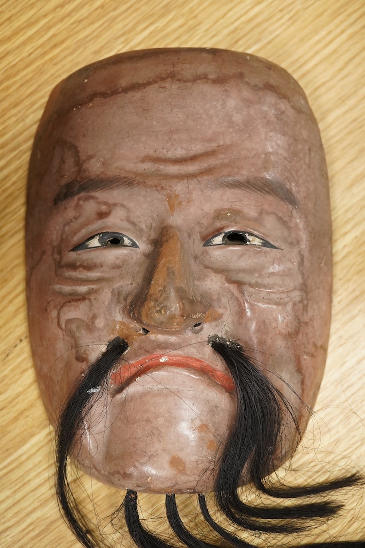 A wooden bowl with a decorative carved rim - 44cm wide across rim and an oriental carved and painted wooden face mask